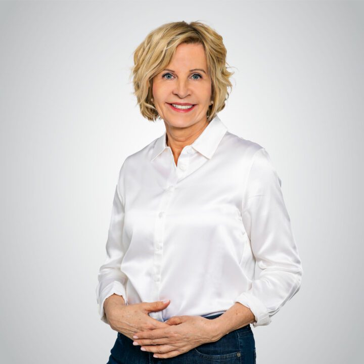 Sabine Heldt - Life Coach aus München stehend vor hellem Hintergrund.